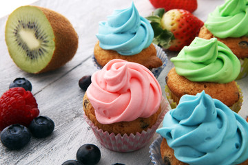 Tasty cupcakes on wooden background. Birthday cupcake in rainbow colors