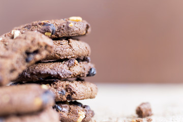 Chocolate chip cookies stacked on sackcloth background.