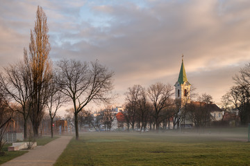 Jedlesee Aupark and church on a misty winter morning at sunrise