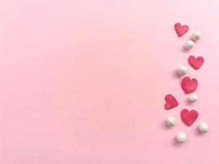 Plasticine clay made are beautiful red heart and white balls, arrange line on right and placed on pink paper background