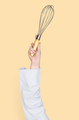 Hand holding a whisk raised up