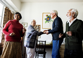 Senior friends dancing together at home