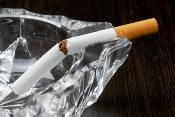 broken cigarette in empty ashtray, stop smoking concept, macro