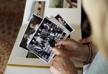 Senior couple looking at family photo album - obrazy, fototapety, plakaty