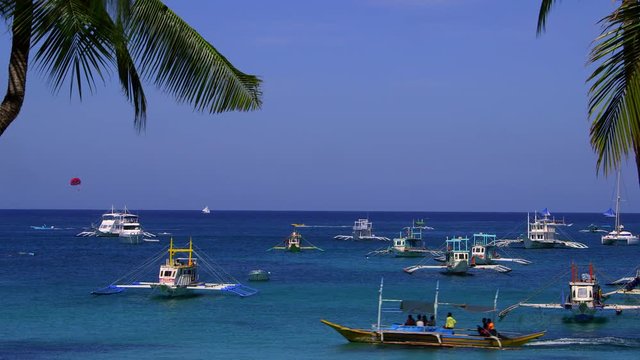 Tourists Jukung Boats In Bay & Palm Trees; White Beach; Boracay Island, Philippines