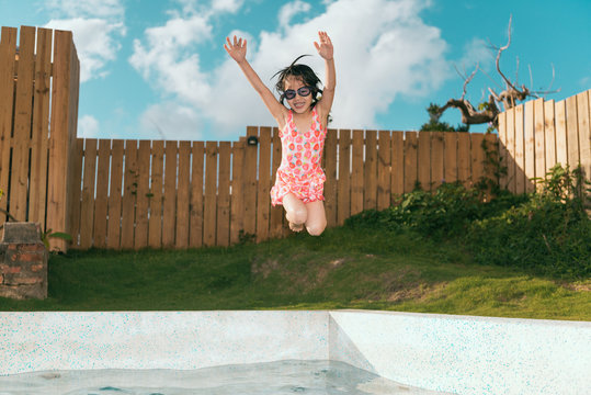 girl children playing in villa swimming pool - Powered by Adobe