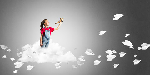 Concept of careless happy childhood with girl dreaming to become pilot
