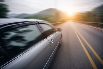 Obraz na płótnie Canvas Car driving on asphalt road at sunset go to travel, motion blur