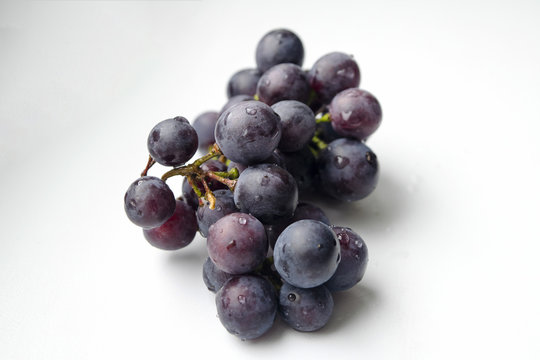 Bunch of blue grapes isolated on white background