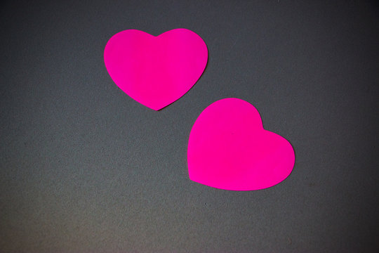Pink paper heart pass on the gray background. Close up photo