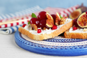 Delicious toasts with fruits on plate, closeup