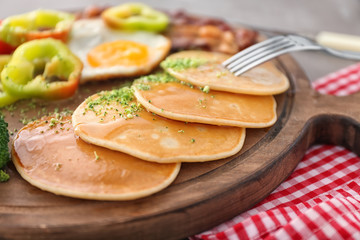 Yummy pancakes on wooden board, closeup