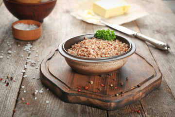 Bowl of tasty buckwheat porridge on table