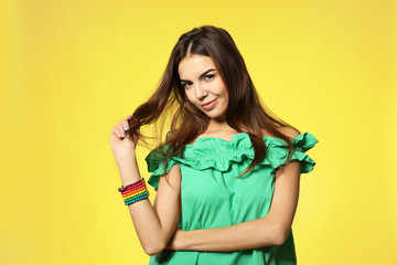 Young beautiful smiling woman on color background