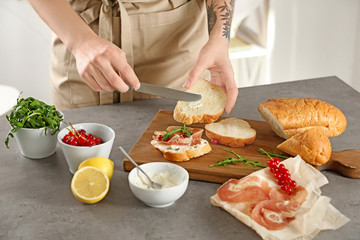 Woman preparing delicious bruschettas on table
