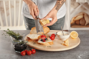 Woman preparing delicious bruschettas on table