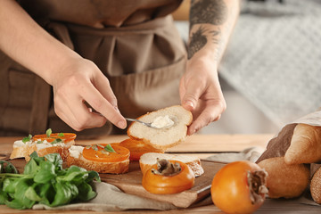 Woman preparing delicious bruschettas on table