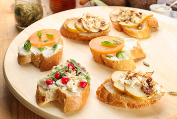 Woman preparing delicious bruschettas on table