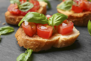 Tasty bruschetta with tomatoes on table