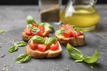 Tasty bruschettas with tomatoes on table