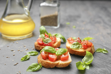 Tasty bruschettas with tomatoes on table