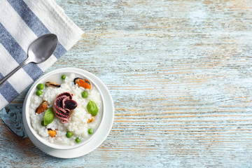 Dish with tasty seafood risotto on wooden background