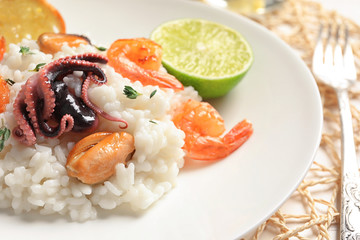 Plate with tasty seafood risotto on table, closeup