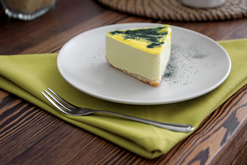 Piece of tasty cake on plate. Table setting in vegetarian cafe