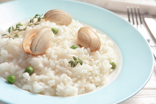 Plate with tasty seafood risotto on table, closeup