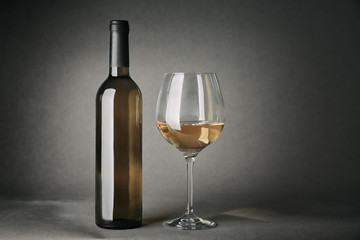Bottle of wine and glass on gray background