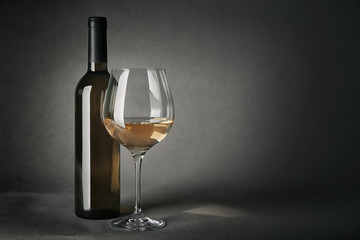 Bottle of wine and glass on gray background