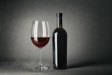 Bottle of wine and glass on gray background