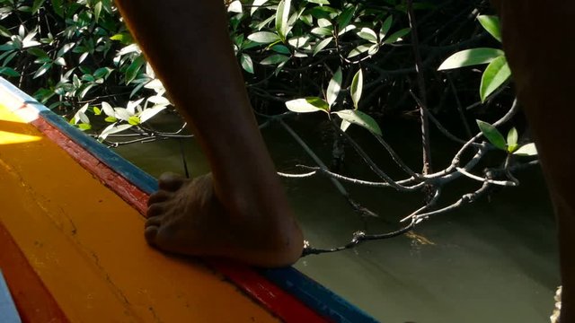 A man is walking along the adge of his fishing boat