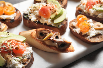 Tasty bruschettas on board, closeup