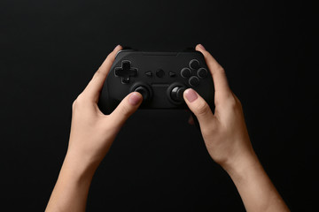Woman holding video game controller on black background