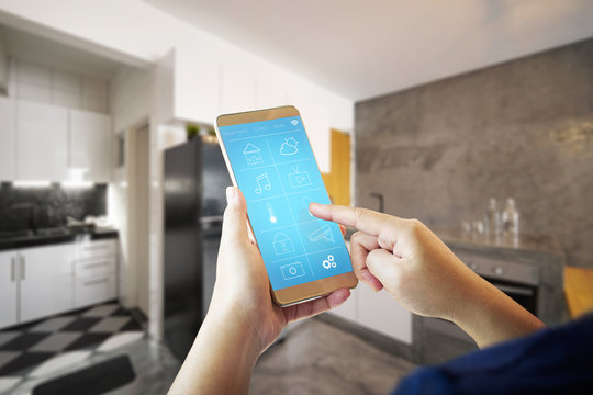Female hand is adjusting lighting with smart phone. .Smart home control concept.