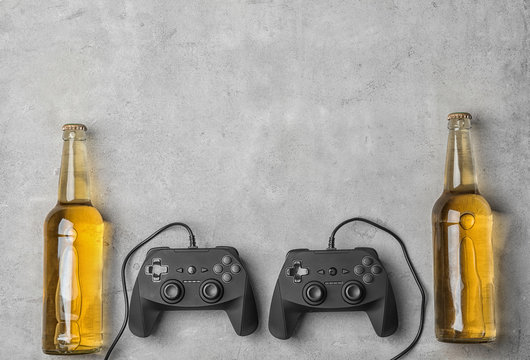 Composition with video game controllers and beer on grey background
