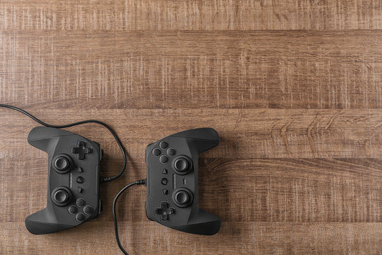 Video game controllers on wooden background