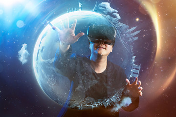 The young man wearing virtual reality goggles with amazing cosmic futuristic space virtual imaging background .