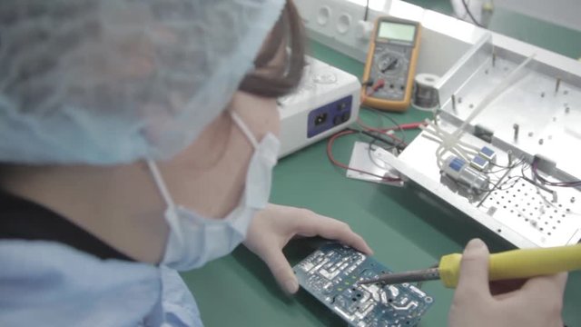 Microchip production factory. Technological process. Assembling the board. Chip. Professional. Technician. Computer expert. Manufacturing. Engineering.