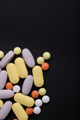  multicolored tablets of oval and round shape on a black background