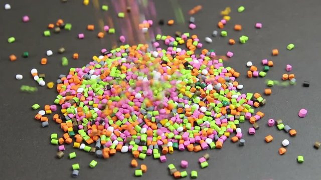 Plastic pellets spilling on background .Polymeric dye ,a colorant for plastics. Plastic raw materials in granules for industry.