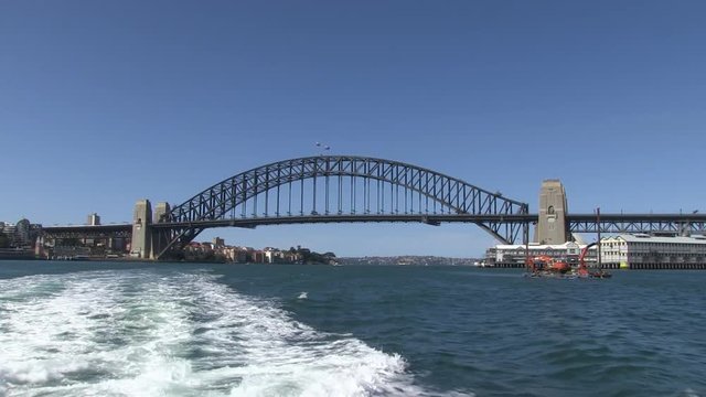 A wide shot of a long bridge and ocean with boats. Camera moves backward ay from the bridge