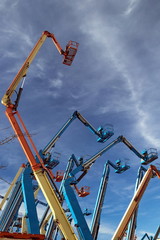 Construction  equipment for rent. Boomlifts  with raised platforms are in the site  for rental...