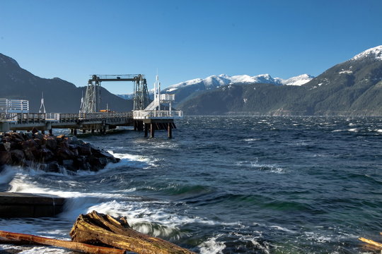 Pier in the bay of  Porteau Cove. Porteau Cove  Provincial Park  located near the "Sea to Sky Hgw", Sunny spring day, sea and mountains, snow-covered mountain range British Columbia.  Canada.  