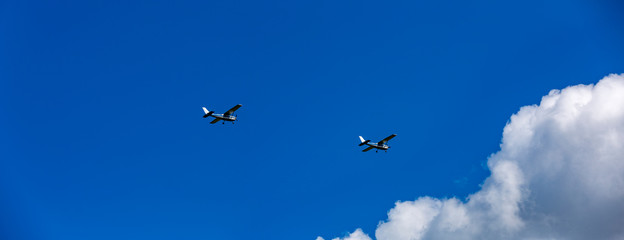 Two airplane flying in the blue sky with cloud
