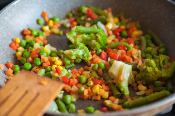 Frozen vegetables for frying in a frying pan. Corn, peas, beans, cabbage. Background and space for your text.