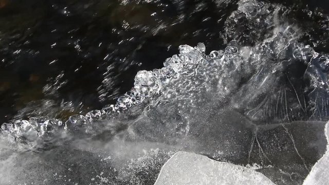 Stormy stream of water under thin ice in the river, Chemal River, Altai, Russia 
