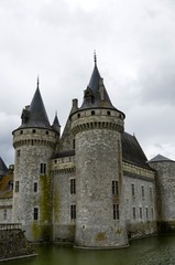 Fototapeta na wymiar Castle of Sully-sur-Loire, Loire region, France. Snap of 30 June 2017 at 18:21. Captured at the entrance of the castle park. White clouds moving on blue sky. Towers well visible in the image.