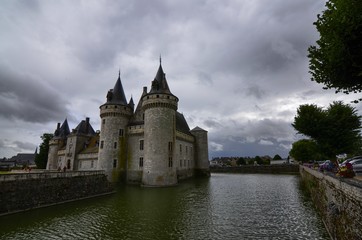 Fototapeta premium Castle of Sully-sur-Loire, Loire region, France. Snap of 30 June 2017 at 18:21. Captured at the entrance of the castle park. White clouds moving on blue sky. Towers well visible in the image.